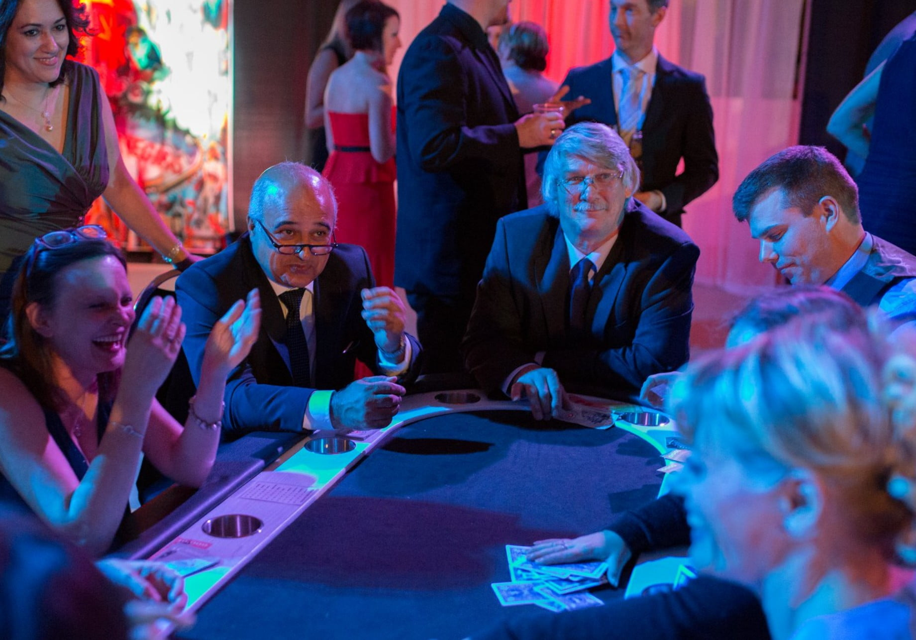 A group sitting at a poker table playing a game