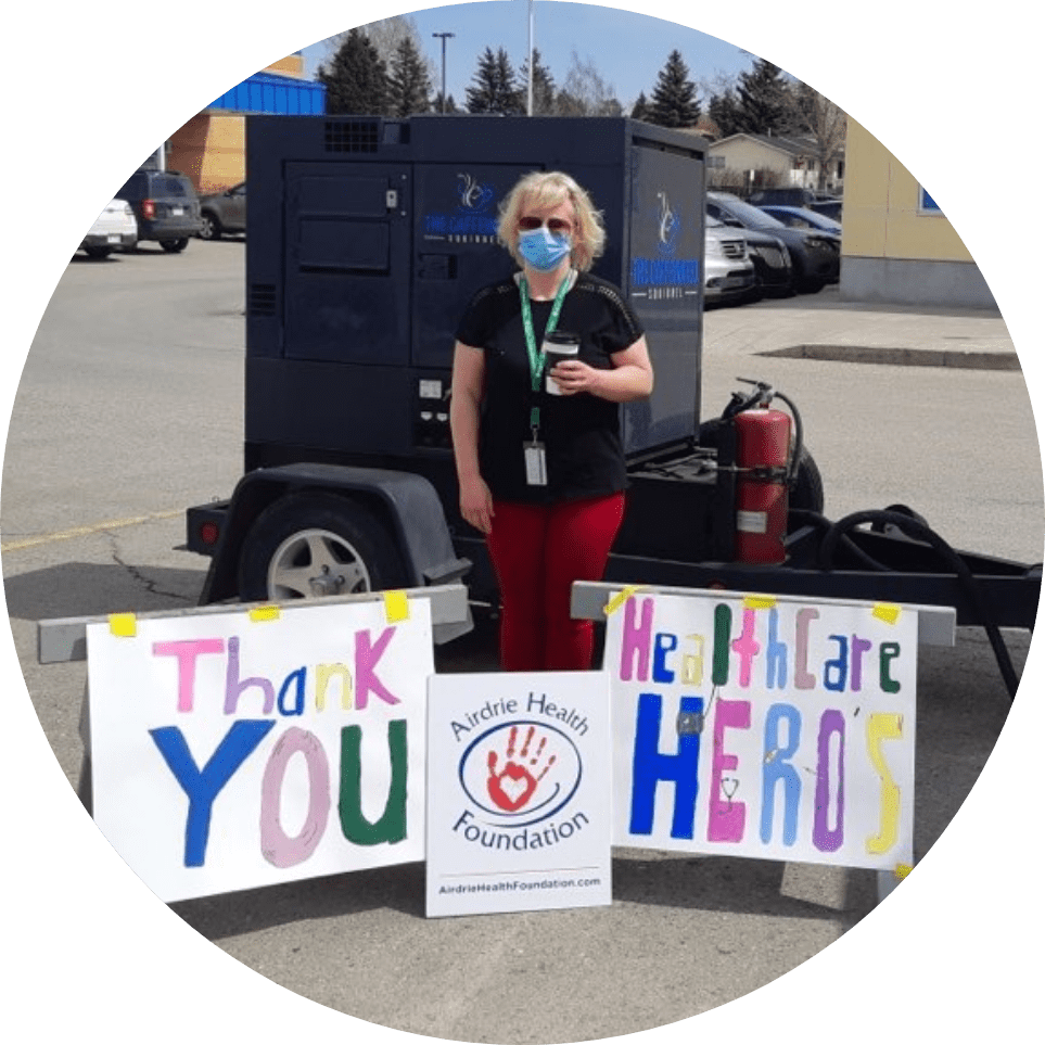 a person standing behind signs that are thanking healthcare workers.